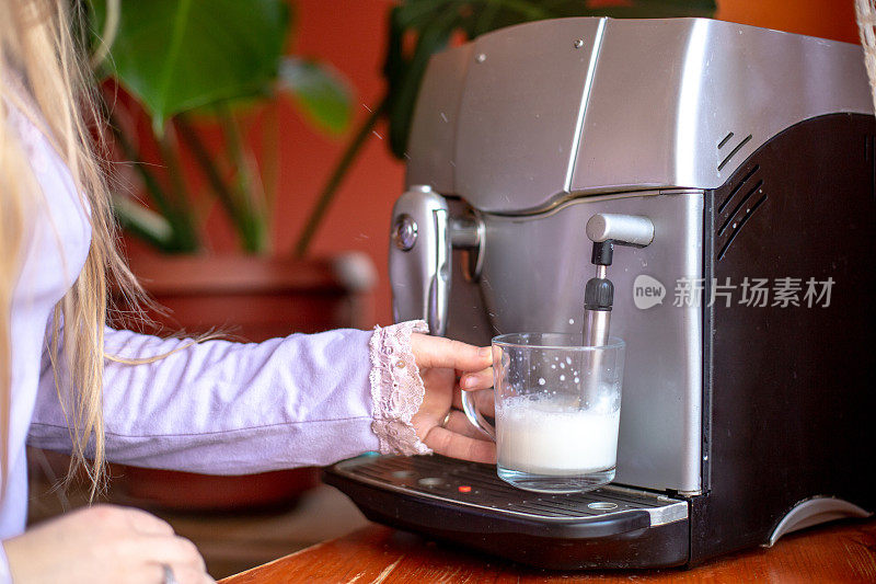 女人在厨房用咖啡机煮咖啡/蒸拿铁牛奶